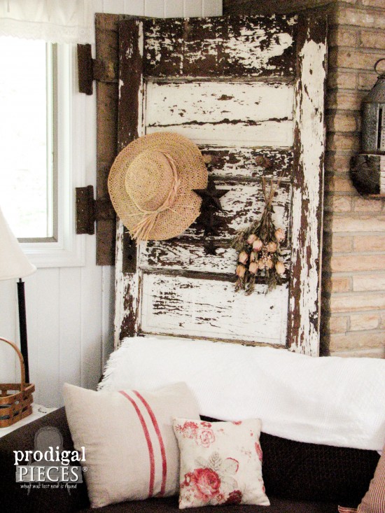 Antique chippy white door becomes functional decor with the addition of barn beam pegs by Prodigal Pieces. www.prodigalpieces.com